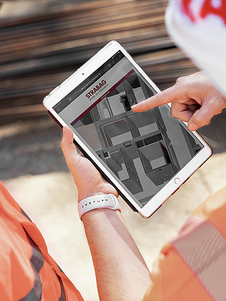 Photo showing two STRABAG engineers looking at a BIM model on a tablet