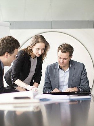 Photo of a team discussing something in a meeting.