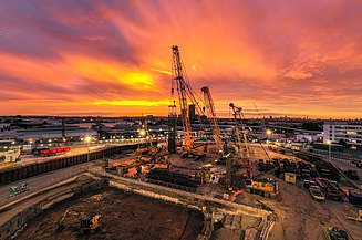 A building site with cranes at sunset