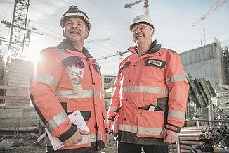 Picture of two men on a construction site laughing