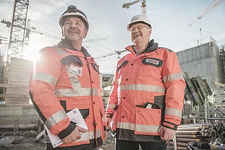 Photo de deux hommes sur un chantier de construction en train de rire